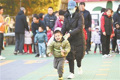 在北京市東城區(qū)欣苑幼兒園舉辦的“冬日暖陽 樂享運動”親子運動會上，家長陪伴孩子共同體驗運動的快樂，家校聯(lián)手呵護孩子健康成長。 新華社記者 金良快攝