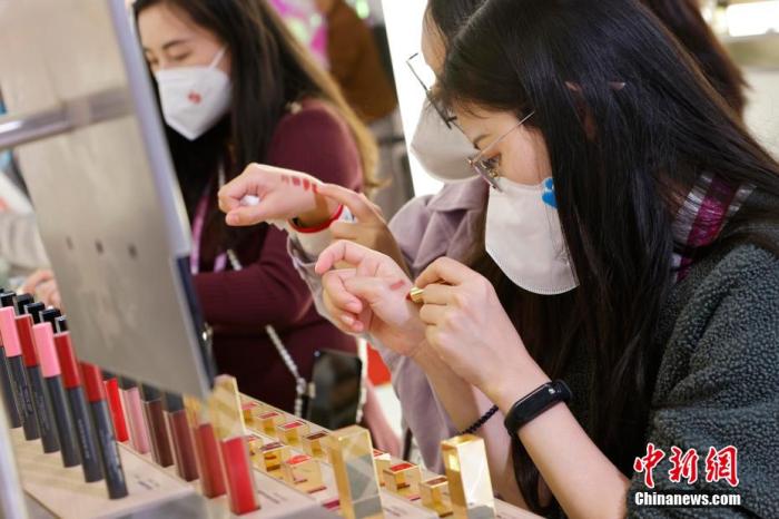 圖為女生正在體驗(yàn)口紅產(chǎn)品。 殷立勤 攝