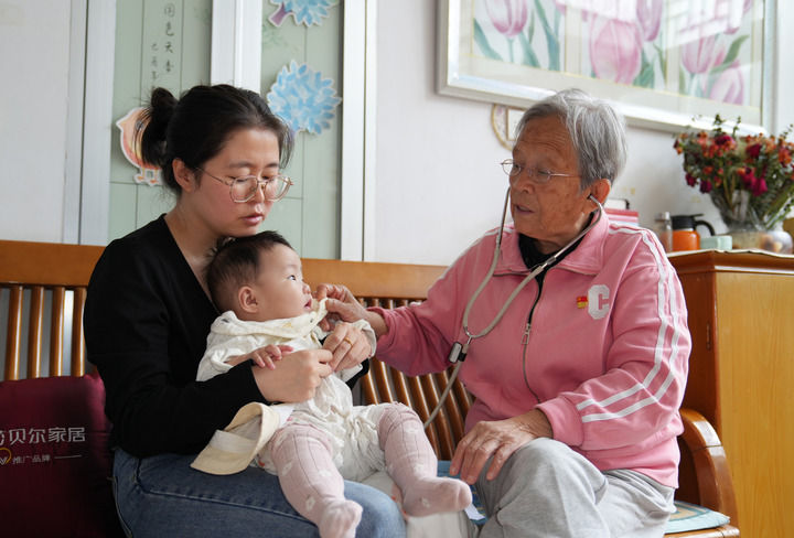 2024年9月10日,在陜西省榆林市佳縣,路生梅在自己的住所為患兒聽診。新華社記者 吳鴻波 攝